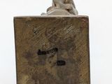 a small bronze statue of a dog on a block