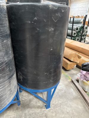 two large black tanks sitting on the floor in a warehouse