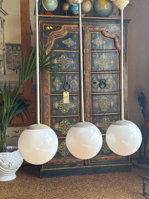 three globes on top of a cabinet in a living room