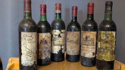 several bottles of wine are lined up on a wooden tray