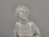 a white statue of a woman sitting on a table