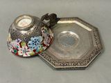 a silver plate with a silver lid and a silver plate with a flower design on it