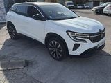a white suv parked in a parking lot next to a wall