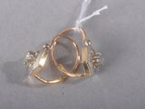 une bague en or sertie d'un diamant, posée sur un fond blanc