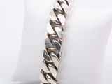 a close up of a silver bracelet on a white napkin