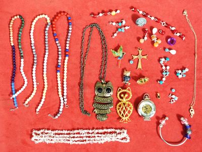 de nombreux colliers et bracelets de toutes sortes disposés sur un fond rouge
