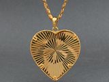 a close up of a heart shaped locke on a gold chain