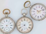 three silver pocket watches with roman numerals and roman numerals
