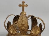 une couronne en or surmontée d'une croix, posée sur une table
