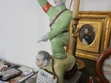 une statue représentant un homme, posée sur une table avec une lampe