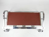 a metal tray with a red leather seat on top of it