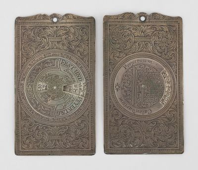 deux étiquettes anciennes en métal, ornées de motifs élaborés, sur un fond blanc