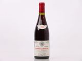 la bouteille de vin rouge est posée sur une surface blanche