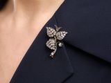 a close up of a person wearing a suit and a broochet