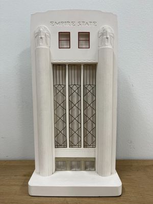 a small white building with a window on top of a table