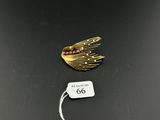a close up of a gold plated brooch with a tag on it