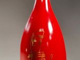 an image of a red bottle with a gold cap on it