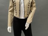 a mannequin wearing a beige jacket and black pants