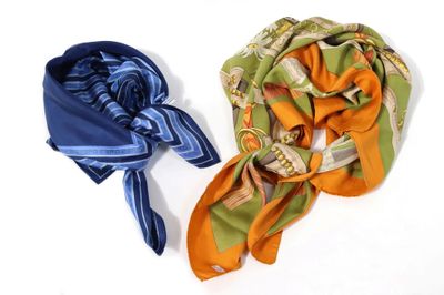 deux écharpes posées sur une surface blanche : l'une est orange et l'autre est bleue