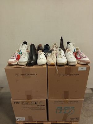 several pairs of shoes are stacked on top of boxes in a room