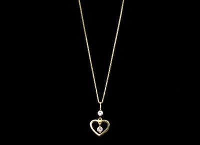 un collier en or avec un pendentif en forme de cœur sur une chaîne