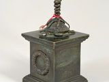 a bronze statue of a man holding a candelab