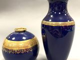 a blue vase and a gold vase sitting next to each other
