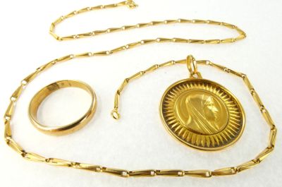 un collier en or et une bague sur laquelle est gravée une image de Jésus