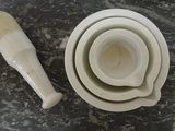 three bowls and a spoon sitting on a marble table