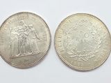 two silver coins, one of which is a woman and one of which is a man