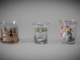 three different colored glass vases sitting next to each other on a table