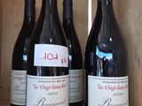 trois bouteilles de vin rouge sont posées sur une étagère dans une caisse en bois