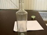 a bottle of water sitting on a table next to a piece of paper