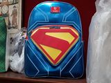 a superman backpack sitting on a table next to other items