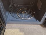 a silver oven with a wire rack inside of it
