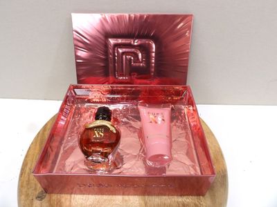 une boîte rose contenant un flacon de parfum et un flacon de lotion