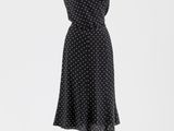 une robe à pois noirs et blancs posée sur un mannequin