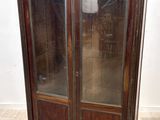 une photo d'une armoire en bois avec des portes vitrées dans une pièce