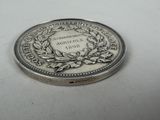 an image of a silver coin with a wreath on it