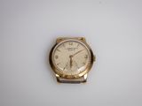 une image d'une montre-bracelet en or sur une surface blanche