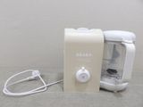a small blender sitting on a table next to a wall