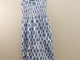 a white and blue dress hanging on a hanger in a room