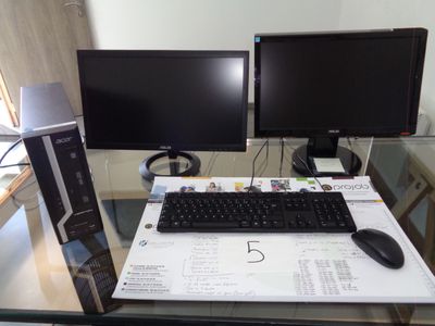deux écrans d'ordinateur et un clavier sur un bureau