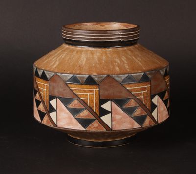 a vase with geometric designs on it on a black background