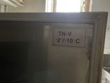 a small refrigerator in a kitchen with a sign on the door