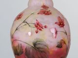 a pink vase with flowers painted on it on a table