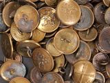 a pile of gold and silver buttons on a black surface
