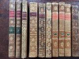 several old books are lined up on a wooden table