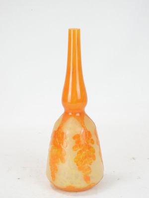 an orange glass vase with a flower design on it
