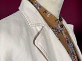 a white jacket with a floral tie on a mannequin